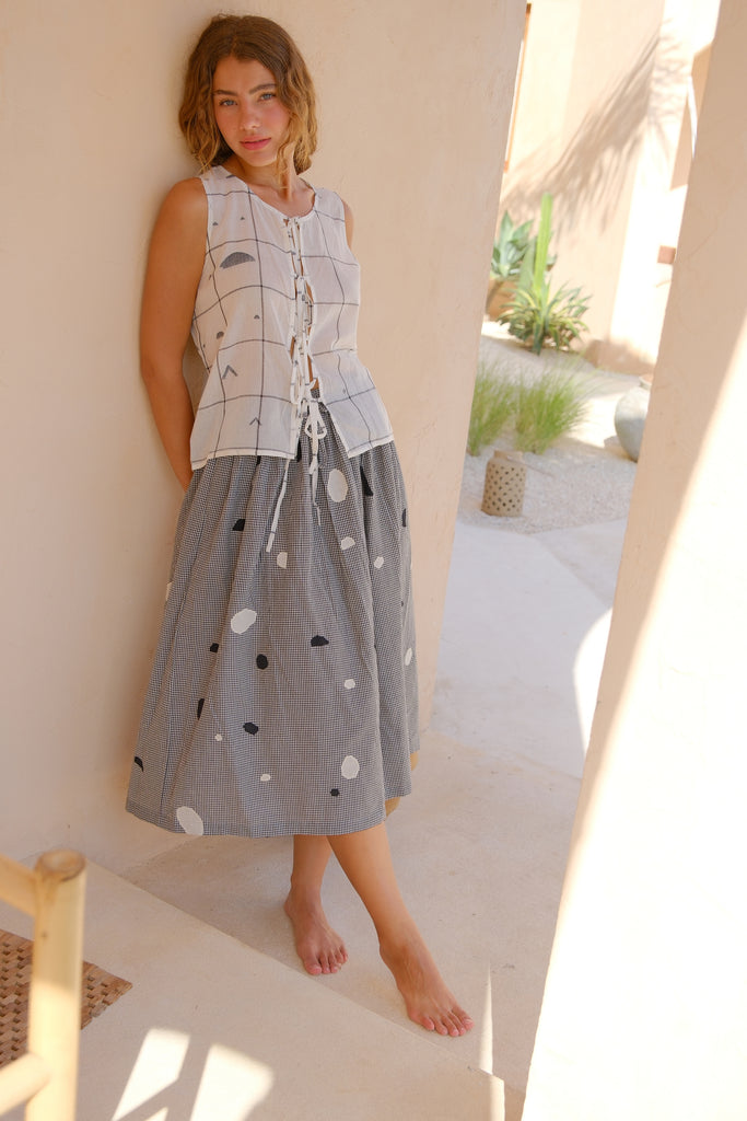 Presenting the All Dots Are Not Black Skirt, a joint creation by Audrey E Leary and World of Crow. This grey midi skirt features unique black and white polka dots on handwoven cotton, combining comfort with style. Crafted sustainably, it’s an ideal choice for daily wear.