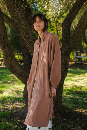 Introducing the Brown Duster jacket, a versatile essential crafted from organic cotton. Designed with a sleek straight collar and adorned with charming coconut buttons, this jacket exudes charm & sophistication. With its straight hem and relaxed fit, it offers both comfort and effortless elegance for any occasion.