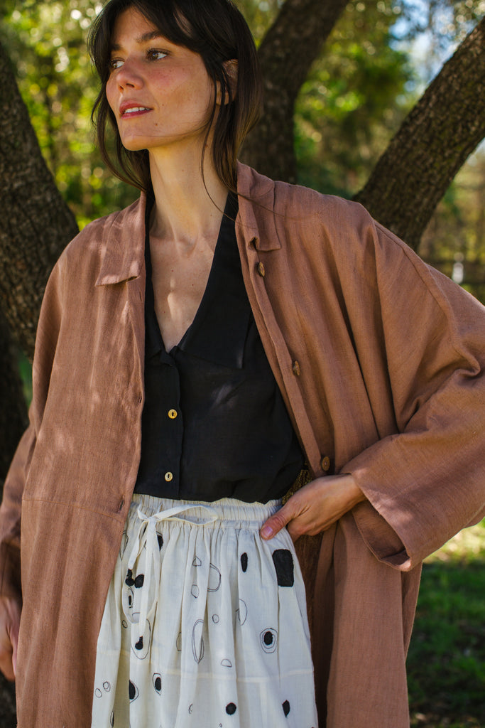 Introducing the Brown Duster jacket, a versatile essential crafted from organic cotton. Designed with a sleek straight collar and adorned with charming coconut buttons, this jacket exudes charm & sophistication. With its straight hem and relaxed fit, it offers both comfort and effortless elegance for any occasion.