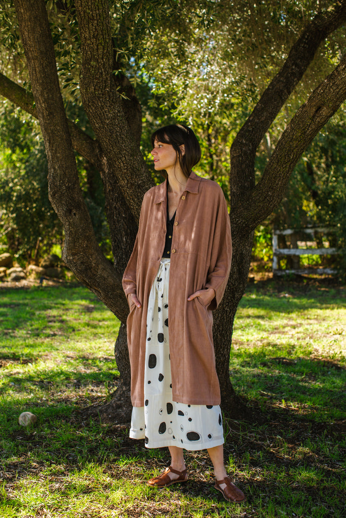 Introducing the Brown Duster jacket, a versatile essential crafted from organic cotton. Designed with a sleek straight collar and adorned with charming coconut buttons, this jacket exudes charm & sophistication. With its straight hem and relaxed fit, it offers both comfort and effortless elegance for any occasion.