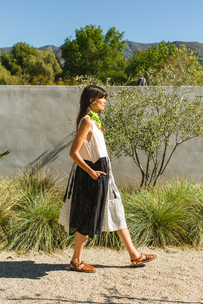 Introducing the Joan dress, a stunning piece in timeless black & white colour. Handwoven from cotton, it showcases intricate appliqué and patchwork detailing for a touch of artisanal charm. Featuring a flattering round V-neck and sleeveless design, this A-line dress offers both elegance and comfort. Complete with convenient side pockets and a midi-length silhouette, it's the epitome of effortless style for any occasion.