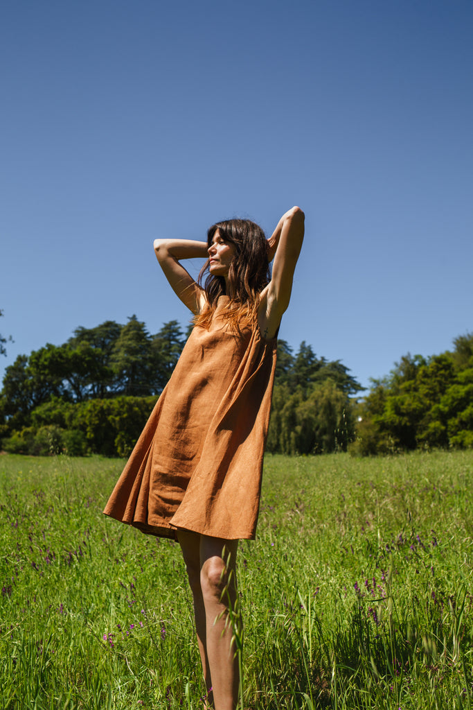 This noon dress is made in collaboration between Erica Kim and World of Crow, it has linen fabric, Brown rustic color, sleeveless, above knee-length dress, it is sustainably made and true to size