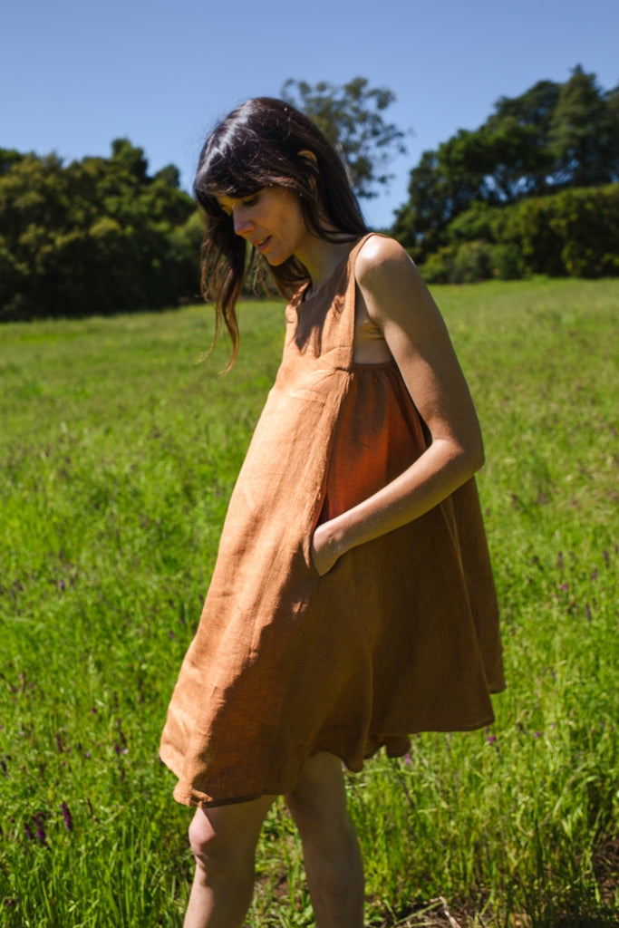 This noon dress is made in collaboration between Erica Kim and World of Crow, it has linen fabric, Brown rustic color, sleeveless, above knee-length dress, it is sustainably made and true to size