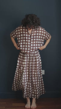 Brown and off-white checkered cotton midi skirt featuring an elasticated waistband, gathered A-line silhouette, and lightweight textured weave. A breathable, relaxed-fit skirt for women, perfect for everyday wear, travel, summer, and resort styling.